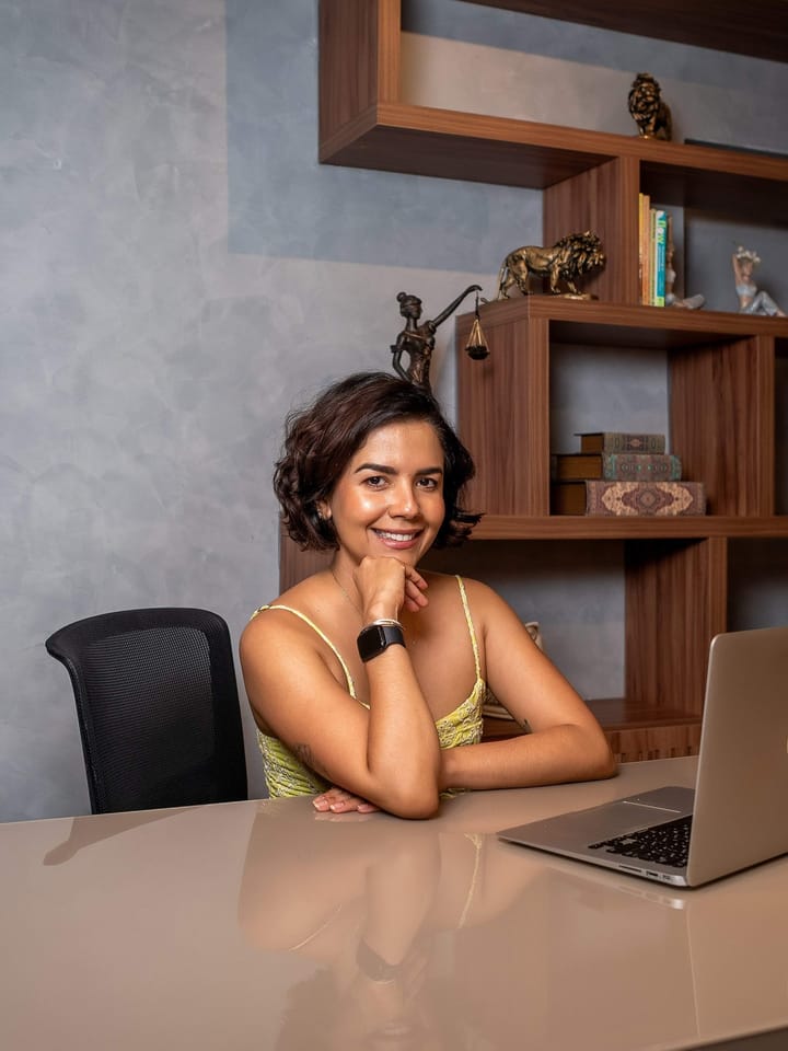 Raquel Chaves, nutricionista, sorrindo sentada à mesa do consultório